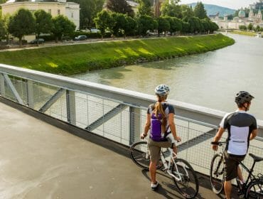 ©SalzburgerLand Tourismus - short break with beautiful view, 2 cyclists on bridge over Salzach - Tauern cycle path