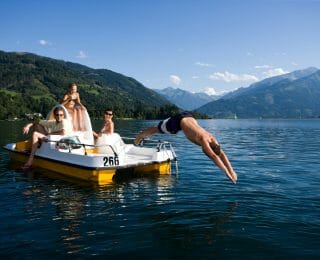 Familie am gelben Tretboot - Kind köpfelt ins Wasser