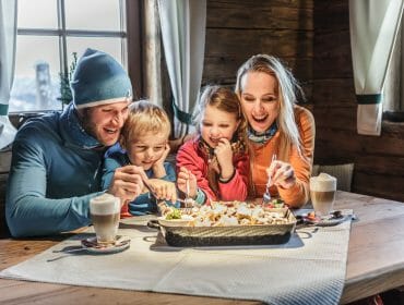 Familie genießt Kaiserschmarrn in der Skihütte.