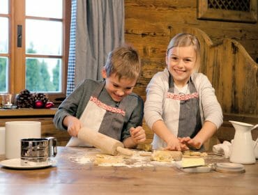 a little boy and a girl baking at a table