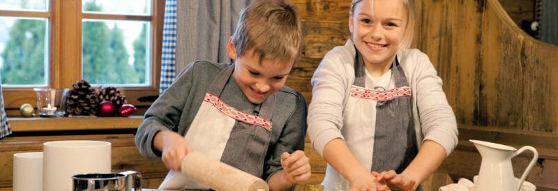 a little boy and a girl baking at a table
