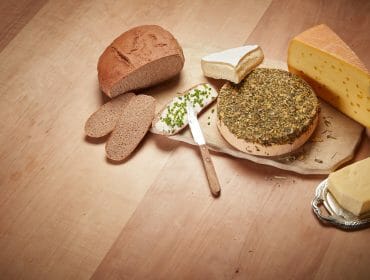 Cheese and bread on top of a wooden table