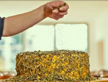 a hand preparing a cake