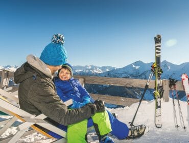 a man and a boy on top of a snow mountain with skis