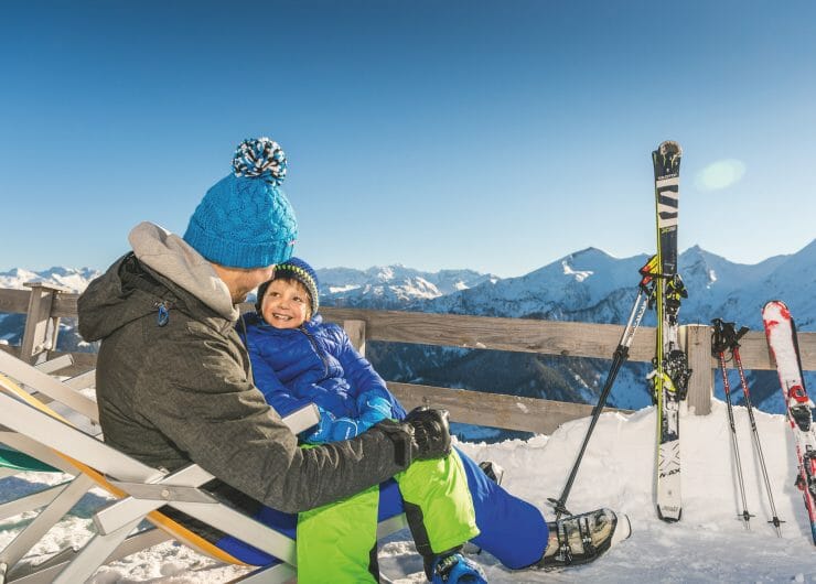 a man and a boy on top of a snow mountain with skis
