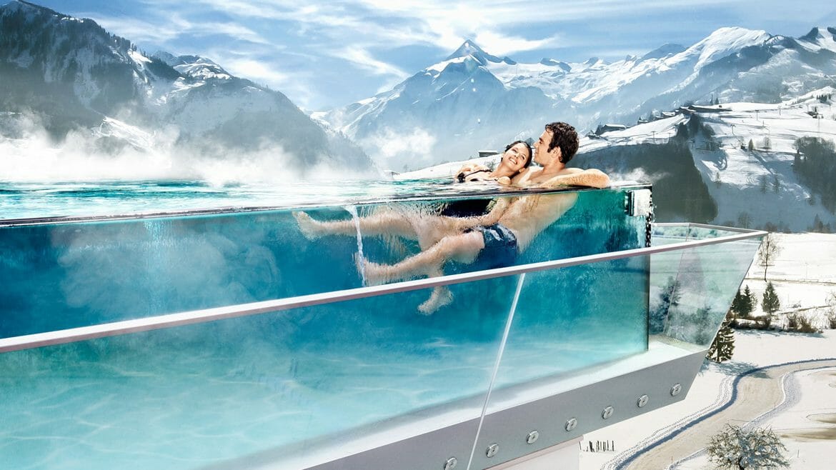 A couple relaxes in the skyline pool of the Tauern Spa Zell am See-Kaprun