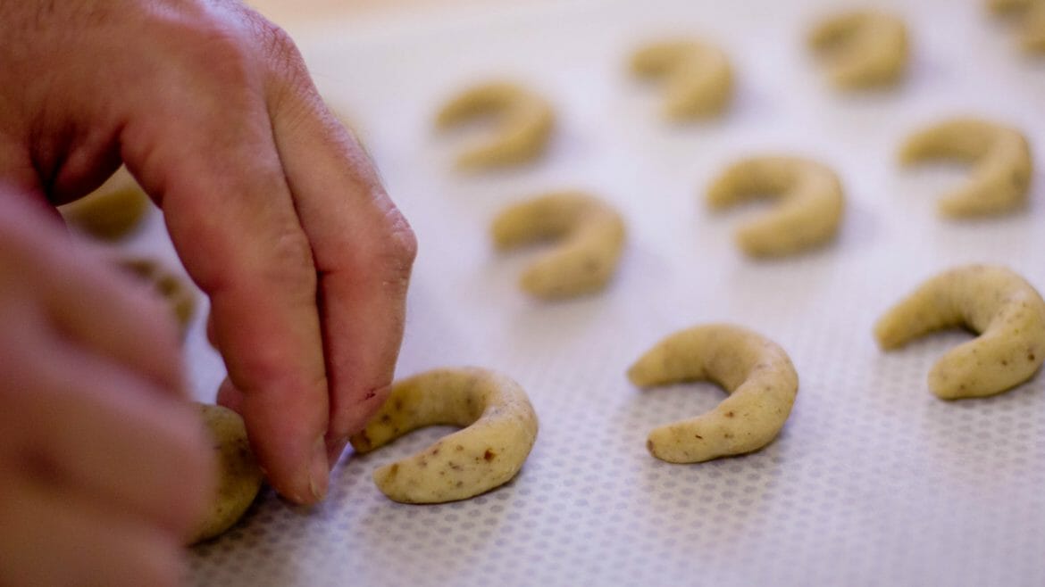 a close up of a hand preparing donuts