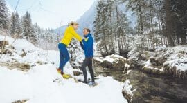 Healthy couple jogging through winter landscape