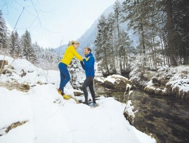 Healthy couple jogging through winter landscape