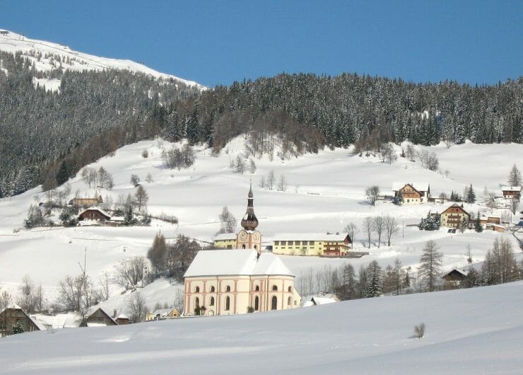  a snow covered mountain and lots of cottages covered in snow