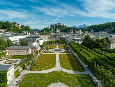 Aerial view of Mirabell Gardens in Salzburg, iconic stop on many Sound of Music tours, city and mountains beyond.