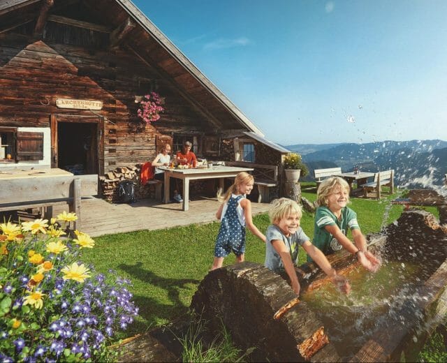 a group of children playing infront of a cottage 