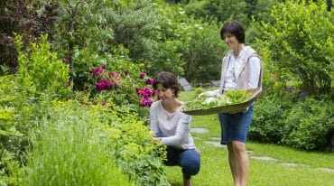 two ladies collecting flowers from the Garden