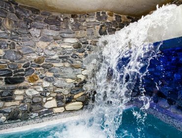 felsentherme-wasser Waterfall cascades from a concrete ledge into a small pool, evoking the calm of natural thermal springs.