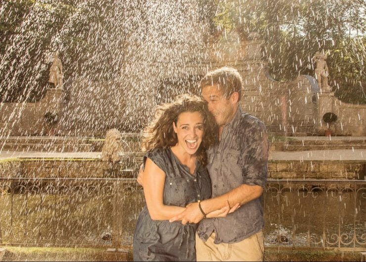 a couple standing in front of a fountain