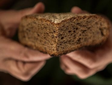 a hand holding a piece of bread
