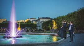 Festival couple dances at illumanted Pegasus fountain by night
