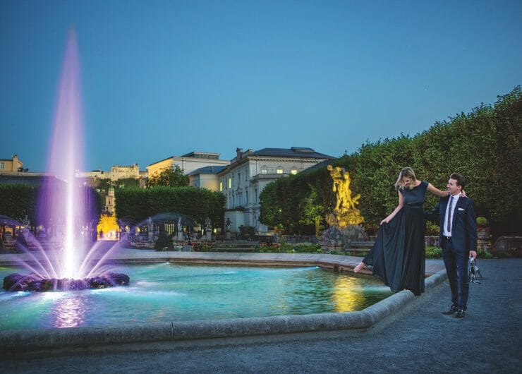 Festival couple dances at illumanted Pegasus fountain by night