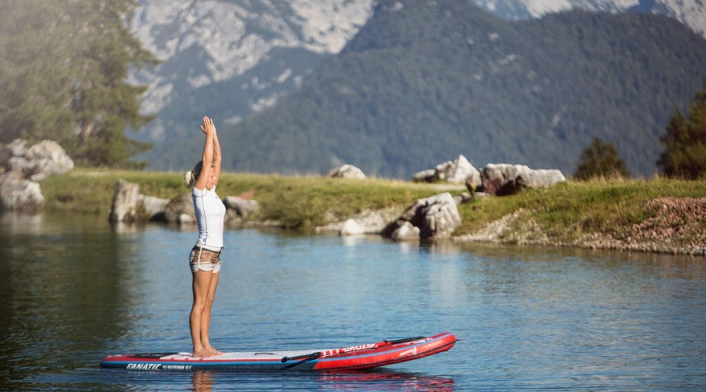 a woman doing yoga in a boat in the water