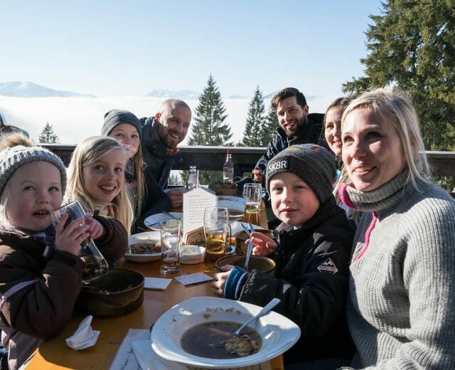 Both families are having lunch at a cosy hut