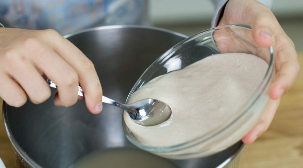 a close up of a person holding a cup and a spoon