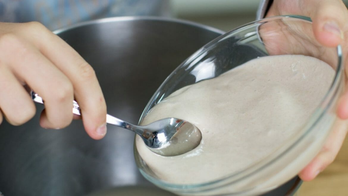 a hand holding a spoon in a bowl