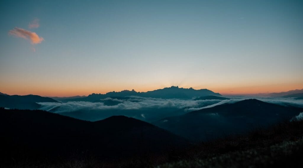 a person flying through the air on top of a mountain