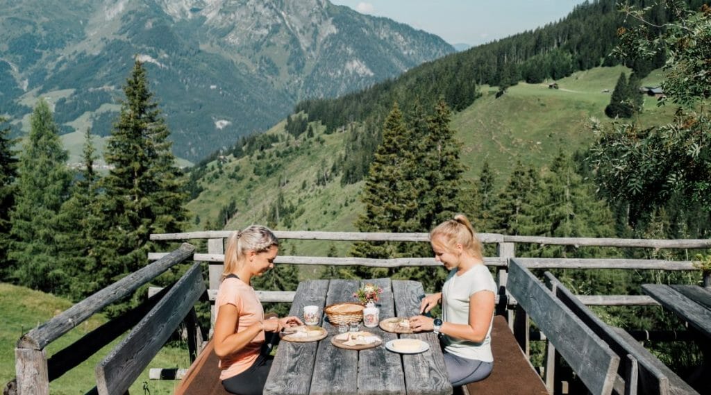 a group of people sitting on a bench with a mountain in the background