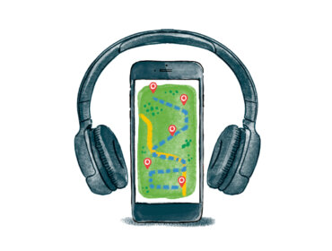 A smartphone with a map on its screen is framed by large headphones wrapping round it.