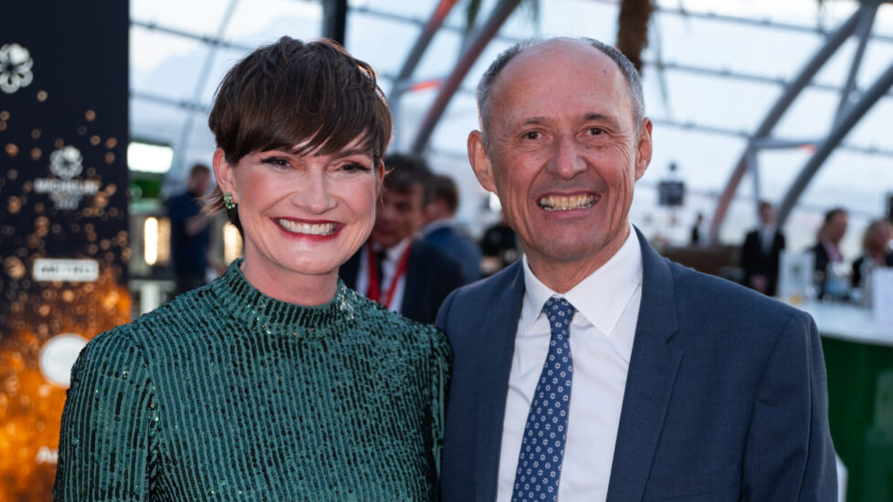 Astrid Steharing-Staudinger in green dress and Leo Bauerbergern in a blue suit smiling together at a formal event.