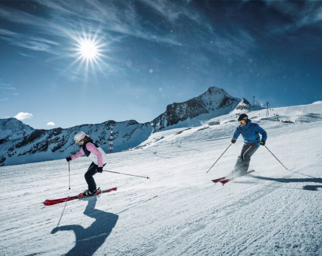 Two skiers on a perfectly groomed ski slope