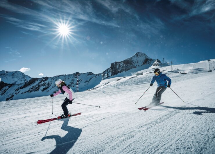 Two skiers on a perfectly groomed ski slope