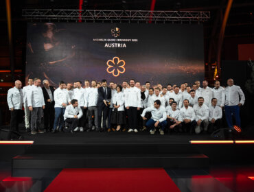 A group of chefs poses on stage at the Michelin Guide Ceremony 2025 in Austria.