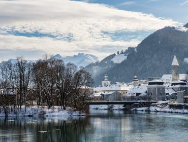 Stimmungsaufnahme Altstadt – Hallein Havas város egy folyó mellett, mögötte hegyek, részben felhős ég alatt - igazi Csendes éj-jeli jelenet.