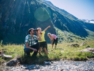 Családi kirándulók a napsütötte hegyek lábánál