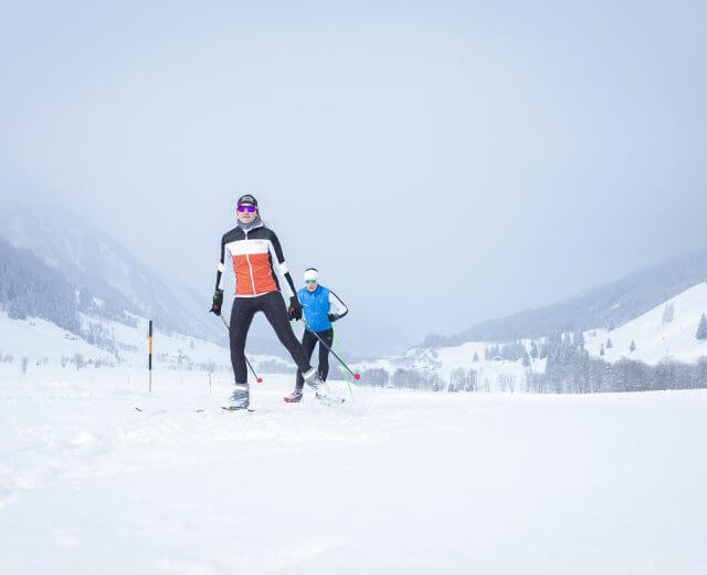 Sífutás a raurisi Hüttwinkltal völgyben Sífutók a ködös tájon a raurisi Hüttwinkltal völgyben