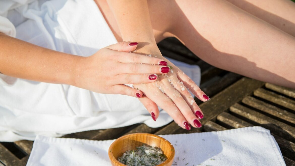 Fehér köntösben lévő nő kezét hámlasztja súrolószerrel, pihenés a salzburgi Lungau régióban télen. (Nagyított nézet)