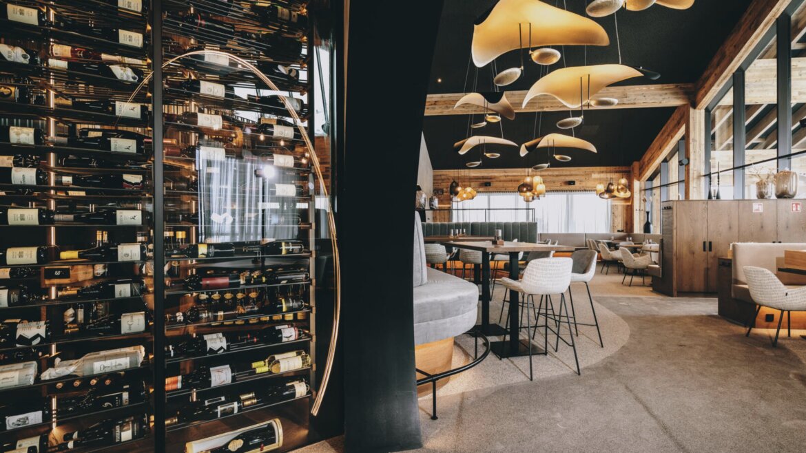 Modern étterem belső kínál kulináris élvezetek Zell am See-Kaprunban és egy elegáns üveg bor kijelző.