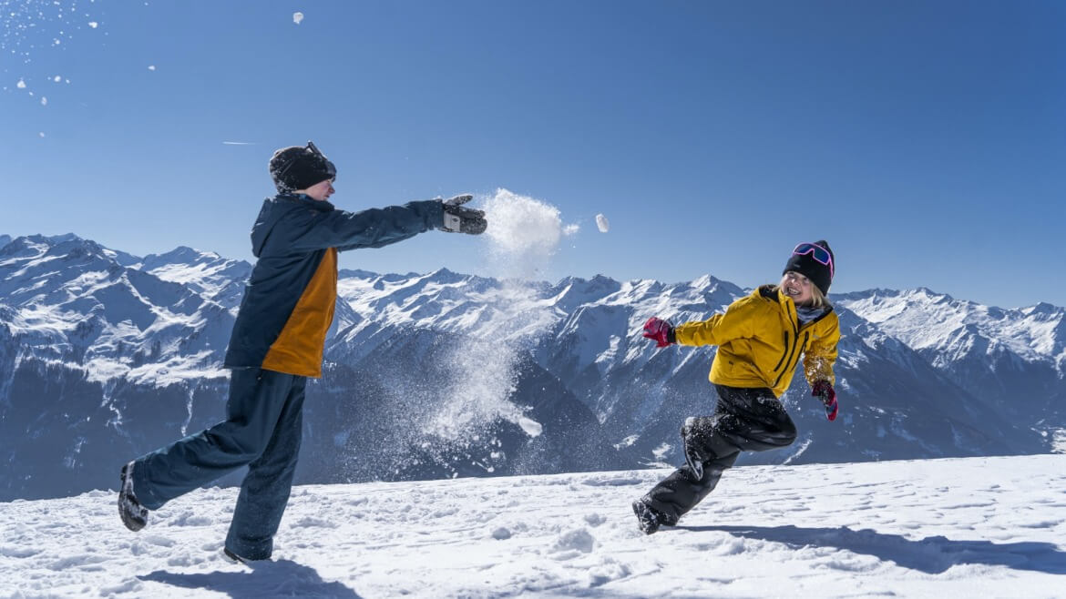 Gyerekek a hóban önfeledten játszanak a Wildkogel-Arena Neukirchen & Bramberg régióban