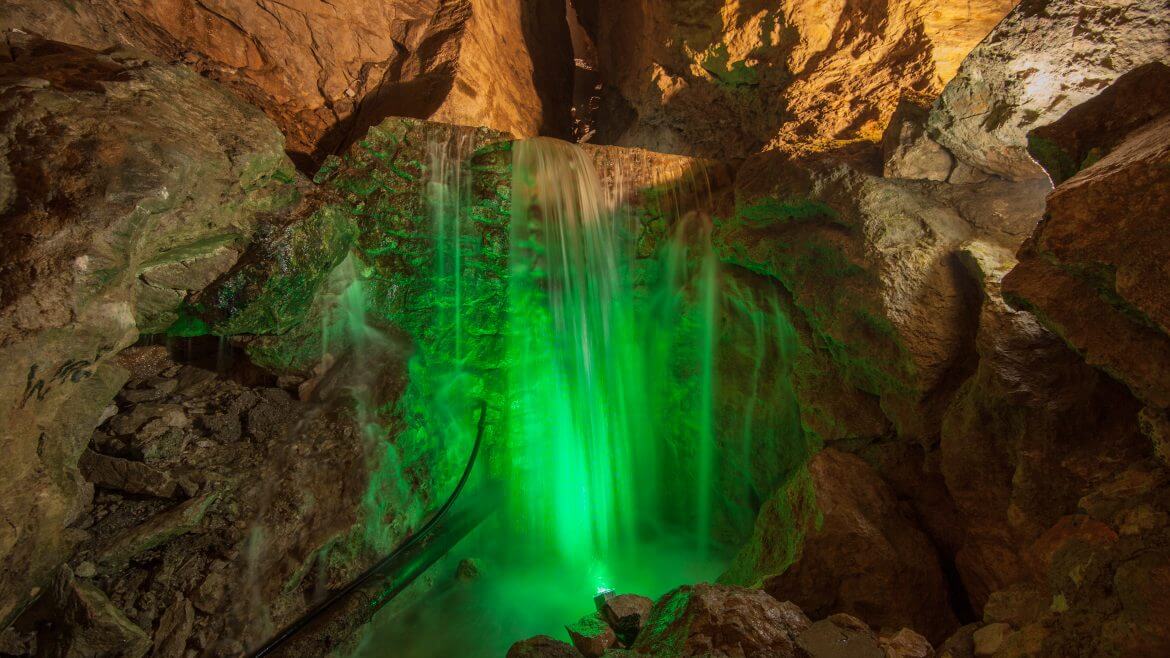 A sziklás Lamprechtshöhle barlangban zöld fénnyel megvilágított víz