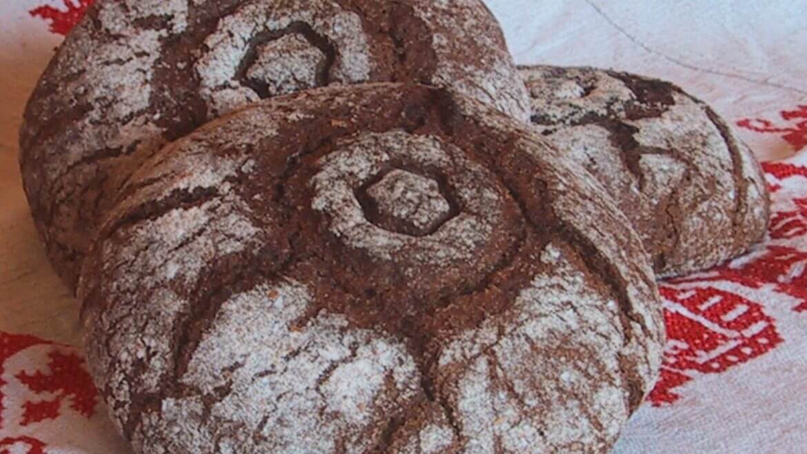 Tauern rozsból készült barna kenyér kerek mintával a tetjén, lisztezve.