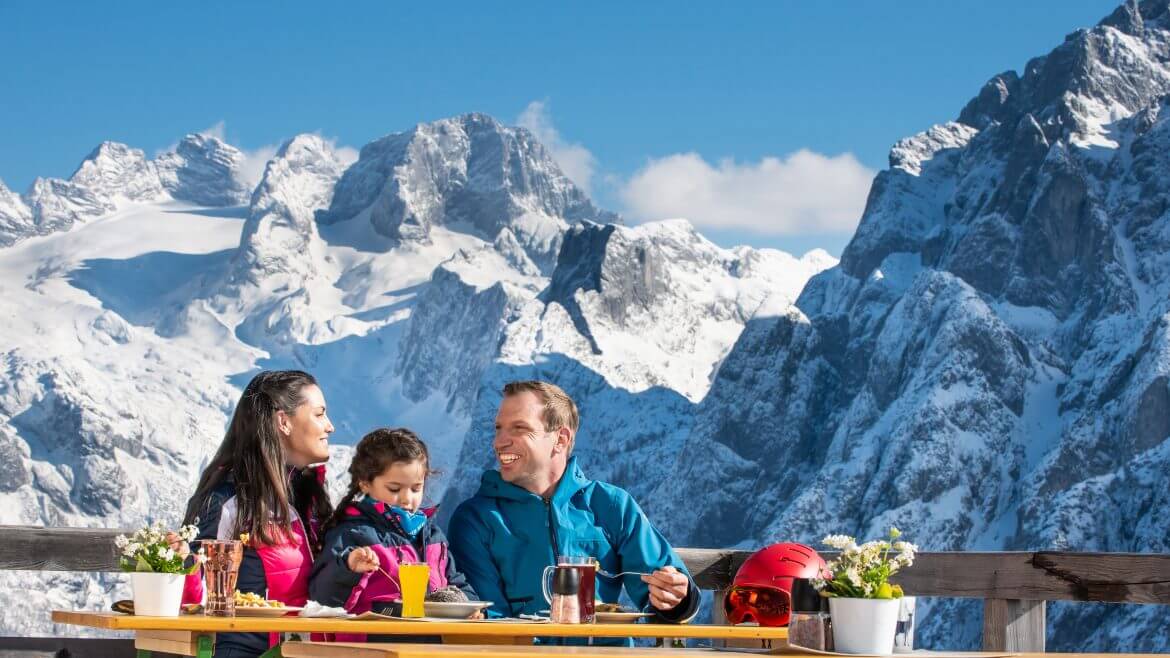 A hangulatos alpesi hütték egyikének teraszán feltöltődik a család, a háttérben a Dachstein.