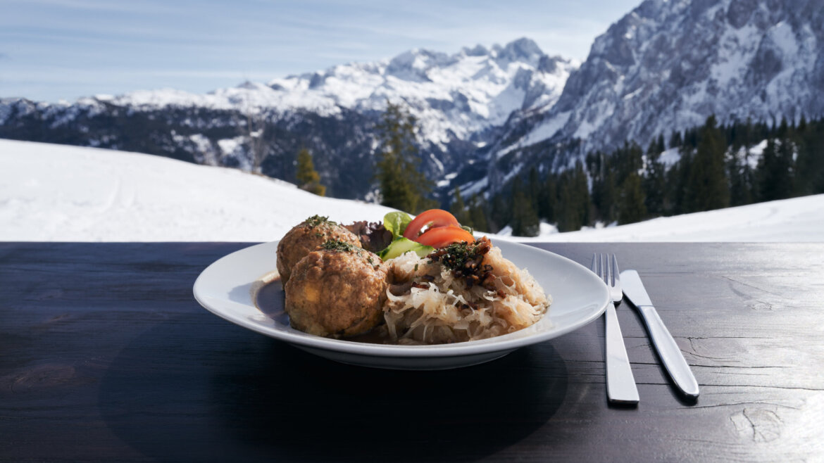 A hangulatos alpesi hütték egyikének teraszán feltöltődik a család, a háttérben a Dachstein