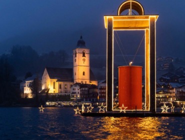 Az úszó Béke lámpás a Wolfgangsee tavon és a zarándoktemplom St. Wolfgangban Az úszó Béke lámpás a Wolfgangsee tavon és a zarándoktemplom St. Wolfgangban