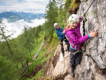 Két ember sziklamászás egy sziklafal-trendi szórakoztató sportok a festői Szent Johannban.