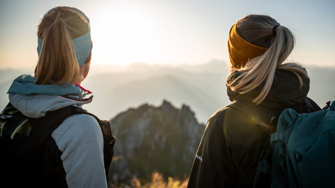 Due donne con lo zaino in spalla ammirano il paesaggio montano all'alba a Grossarl. (Vista ingrandita)