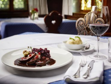 Tavola imbandita con arrosto di cervo e canederli