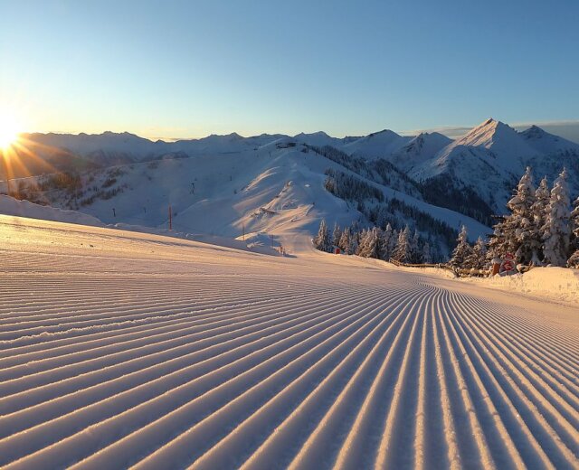 L’alba sulla pista di Grossarl Alba sulle montagne del Grossarltal con pista perfettamente preparata e nessuno in vista: inizia così una giornata perfetta sugli sci