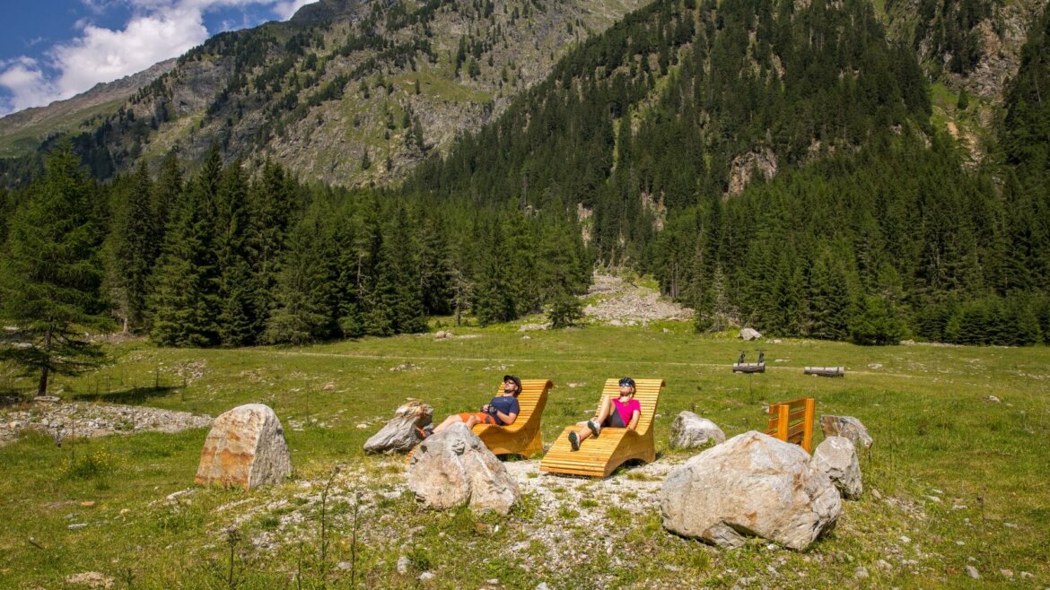 Due ciclisti si rilassano su sdraio in legno nella valle di Göriach nel Lungau Salisburghese