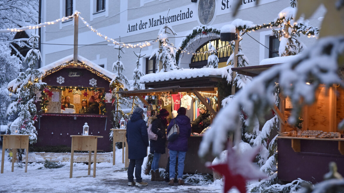 Mercatino d’Avvento davanti al municipio di St. Michael nel Lungau con luci e visitatori (Vista ingrandita)